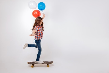 Amused child skateboarding in the studio