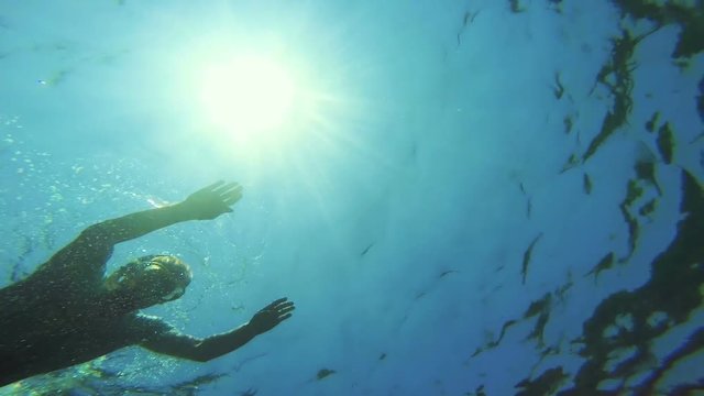GoPro - Man floating on water, bottom of the sea POV.