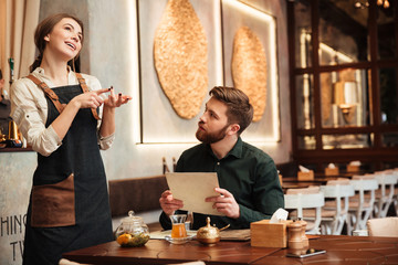 Amazing bearded young man sitting in cafe.