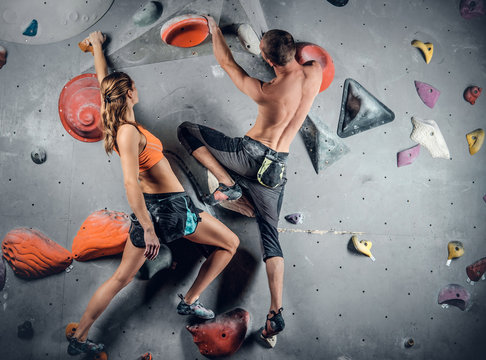 Male and female climbing on a climbing  wall.