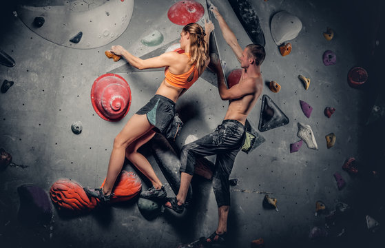 Male and female climbing on a climbing  wall.