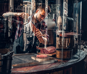 Chef cooking beef steak on a kitchen.