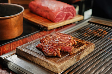The grilled beef steak on a wooden board.