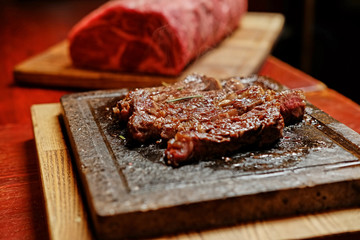 The grilled beef steak on a wooden board.