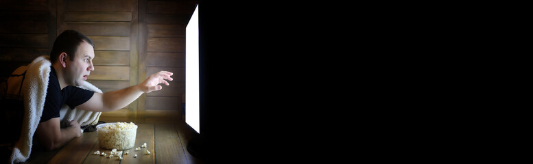 man watching television at home on the floor