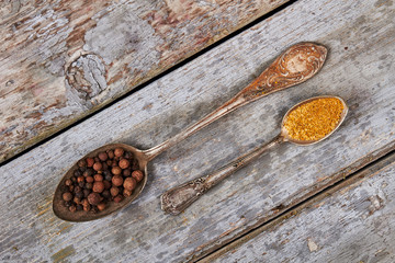 Vintage metal spoons with spices.