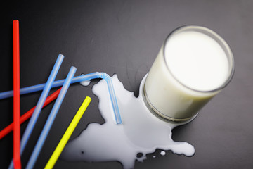 glass of milk splashing and tube straw on table