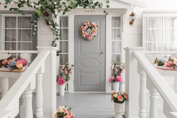 White small wooden house with gray door. spring flower decoration