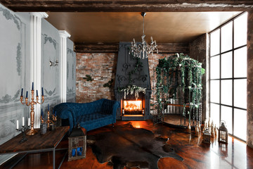 Interior with fireplace, candles, skin of cows, brick wall, large window and a metal cell of a loft, living room, coffee table and dark blue sofa in modern design