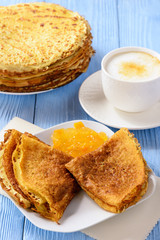 Pancakes with jam and cup of coffee.