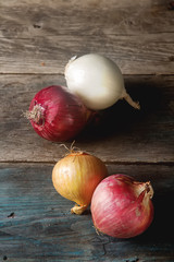 Onions of different varieties and colors. Dark gray background.