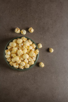 Sweet popcorn in a bowl. Gray background. Watch a movie.