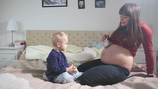 Pregnant woman having fun with her son - tracking shot.FULL HD