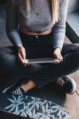 Young girl with skateboard and tablet