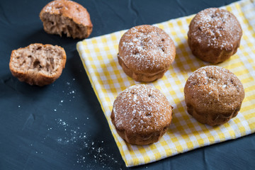 Muffins on yellow towel on table