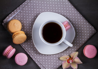 Coffee and cake macaron or macaroon on gray background from above. Flat lay, top view