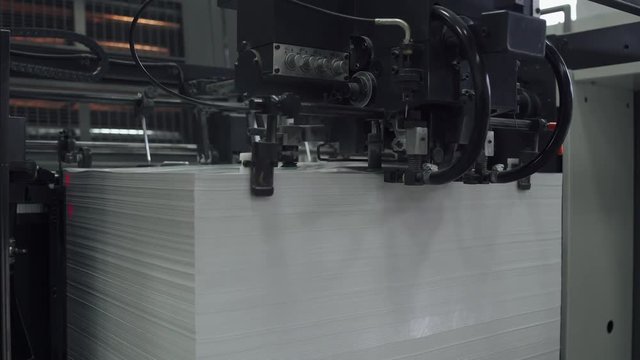 Offset printing press, industrial machine moving the paper material. Print house. Close-up. 4k footage.
