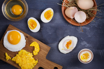 Different ways of cooking eggs: scrambled, omelette, boiled, raw and poached. Flat lay, top view with copy space