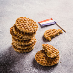 Mini stroopwafel, syrupwaffles cookies and Netherlands national flag light gray background with copy space.