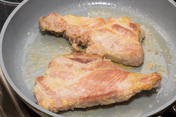Pork shoulder roasted  in a fry pan.