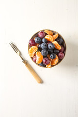 Plate with fruit salad of mandarin, grape, blueberry. Delicious