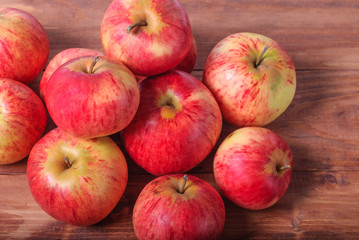 Harvested apples lie on a wooden background.