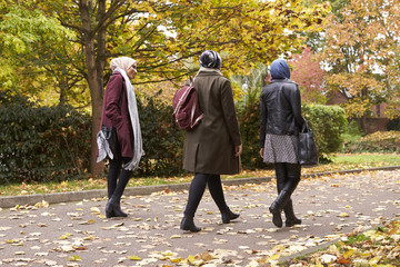 British Muslim Female Friends Walking In Urban Environment