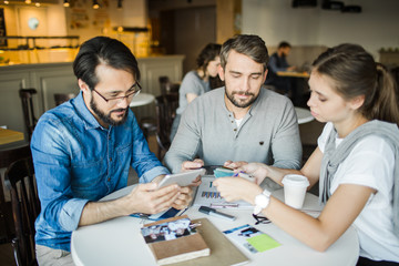 Obraz premium Designers discussing palette and looknig for information about new design trends in the net