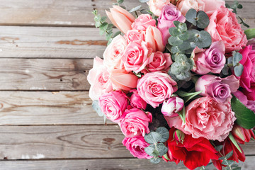 Bouquet of red roses and Other colors flowers on wooden background, copy space. top view