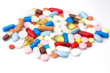 Pharmacy theme. Multicolored Isolated Pills and Capsules on the White Surface. Closeup
