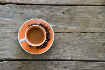 A Cup coffee and beans on wooden from top view