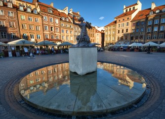 Statue of Mermaid (Syrenka - symbol of Warsaw) at the Old Town Market Square against tenements and...