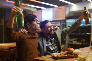 Ecstatic men with beer celebrating victory of football team