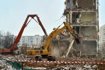 Excavators demoloishing city house