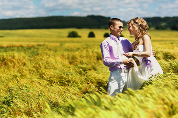 Fototapeta premium Newlyweds have fun in tall wheat