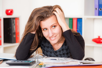 Tired young female employee hard working with papers in the office