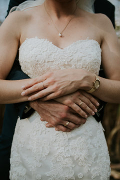 Mid section of bride and groom embracing