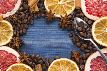 grapefruit and orange slices with coffee beans and spices on wooden background