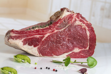 raw beef rib steak with bone with fresh herbs