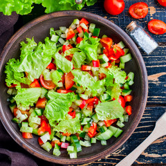 Fresh vegetable salad in a clay bowl, top view