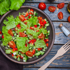 Fresh vegetable salad in a clay bowl, top view