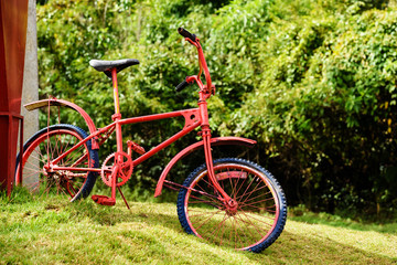 Fototapeta na wymiar Retro red bike parking on field