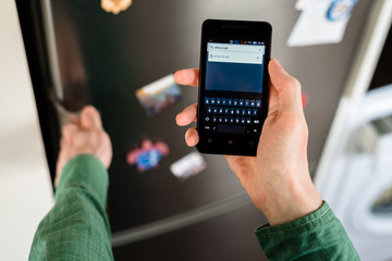 Person hands holding smartphone and searching for places to eat in browser