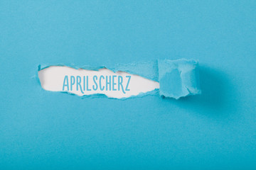 Aprilscherz (German April fools joke) message on Paper torn ripped opening