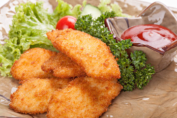 Pieces of chicken fried in batter garnished with vegetables.