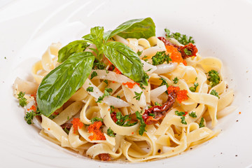 Close up of pasta  with caviar decorated with leaf of basil.