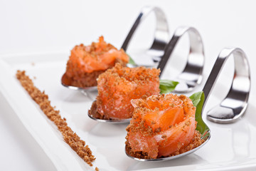 Gourmet appetizer of salmon served in a special decorative spoons.