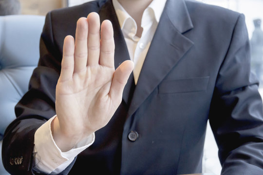 Men's hand showing stop sign