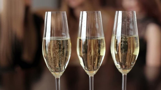Three glasses of champagne on blurred background.