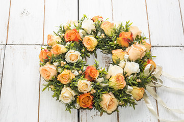 Wedding wreath with roses on white wooden background